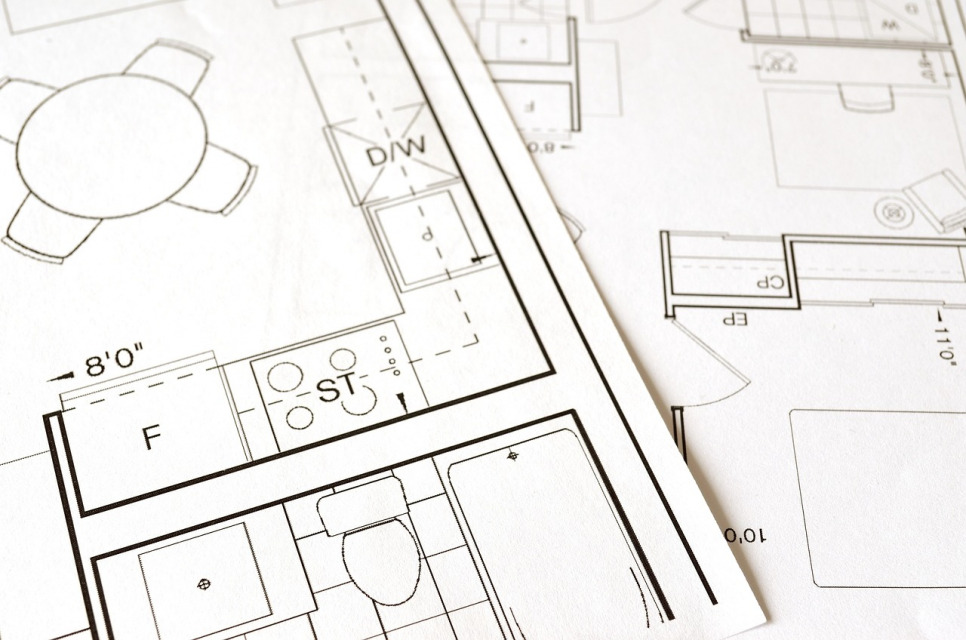 Detailed construction planning documents and blueprints on desk